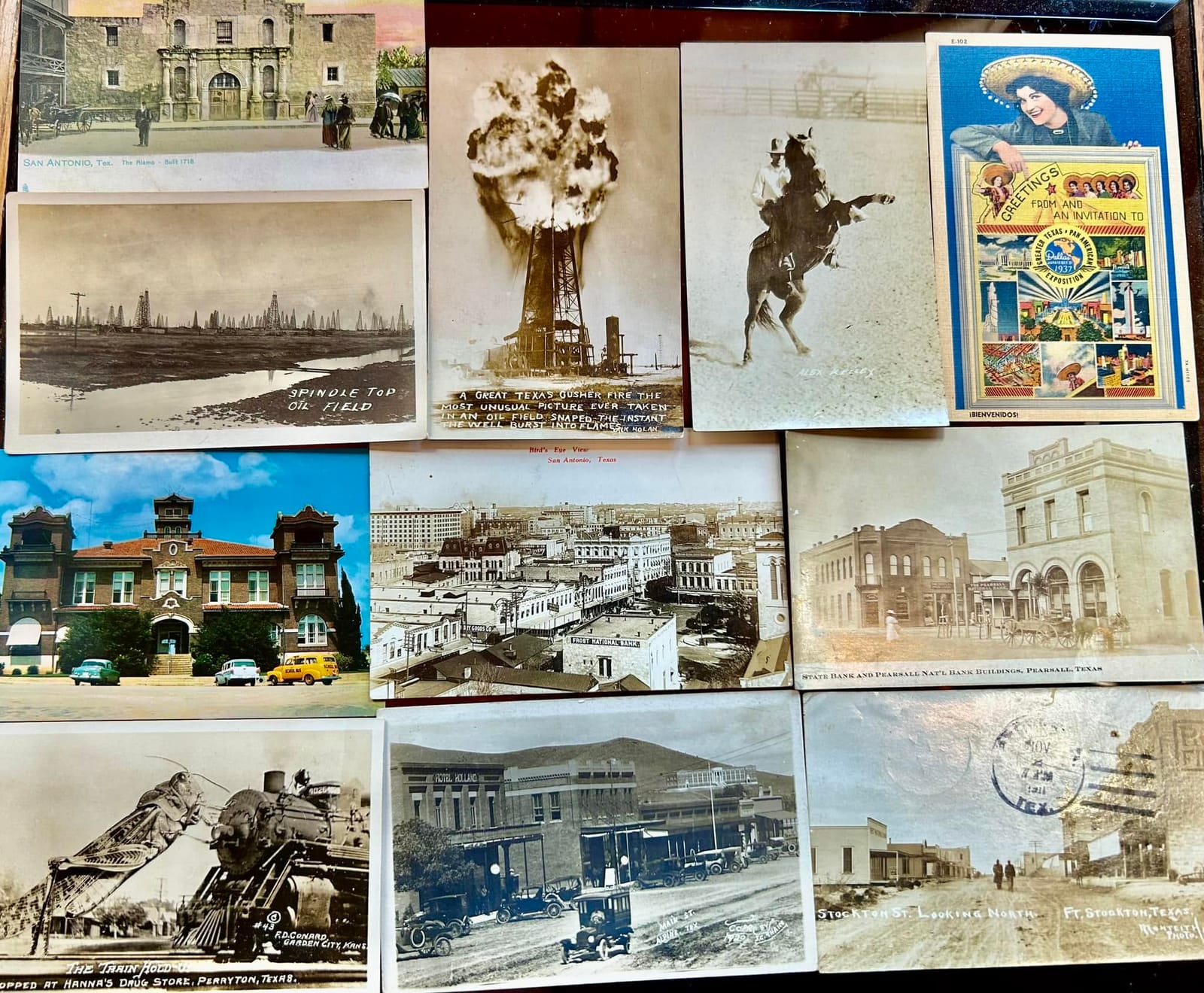 A board of antique Texas postcards including the Alamo, the Spindletop oil field, a burning oil gusher, a bronco rider, and the 1937 Greater Texas Pan-American Exposition.
